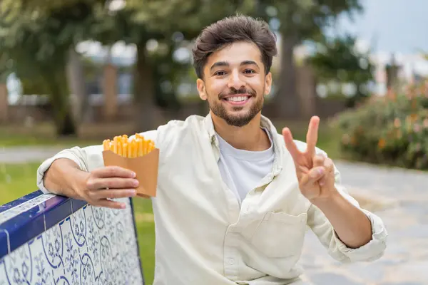 Jonge Arabische Knappe Man Met Gebakken Chips Buitenlucht Glimlachend Met — Stockfoto