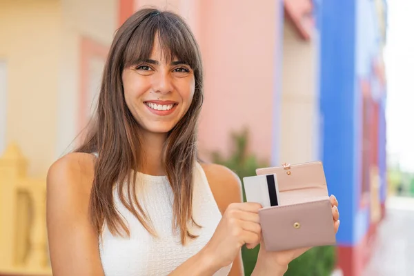 Młoda Kobieta Świeżym Powietrzu Trzyma Portfel Kartę Kredytową Szczęśliwym Wyrazem — Zdjęcie stockowe