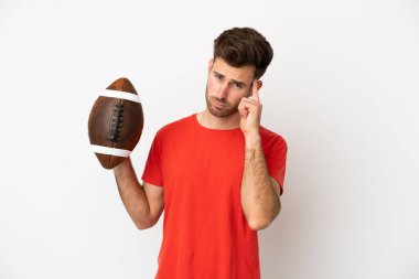 Beyaz arka planda ragbi oynayan beyaz bir adam bir fikir düşünüyor.