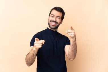 Kafkasyalı yakışıklı bir adam izole edilmiş arka planda gülümseyerek seni işaret ediyor.