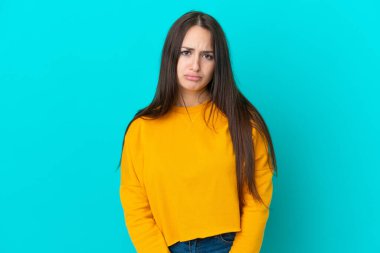 Genç Ukraynalı kadın üzgün bir ifadeyle mavi arka planda izole edilmiş.