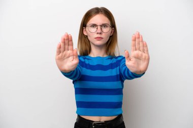 Beyaz arka planda izole edilmiş genç bir İngiliz kadın dur hareketi yapıyor ve hayal kırıklığına uğruyor