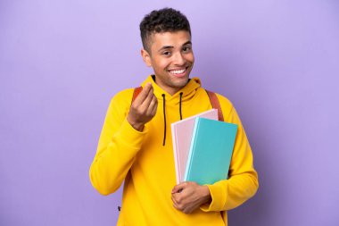 Mor arka planda izole genç Brezilyalı adam para hareketi yapıyor.