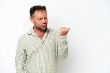 Beyaz arka planda izole edilmiş orta yaşlı beyaz bir adam mutsuz ve kenarı işaret ediyor.