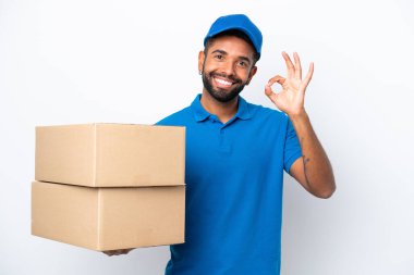 Teslimat yapan Brezilyalı adam beyaz arka planda izole edilmiş. Parmaklarıyla tamam işareti gösteriyor.