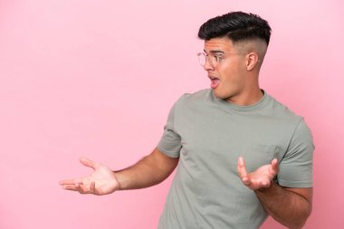 Pembe arka planda mahsur kalmış beyaz, yakışıklı genç bir adam.