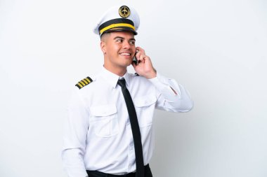 Beyaz arka planda izole edilmiş bir uçak pilotu cep telefonuyla sohbet ediyor.