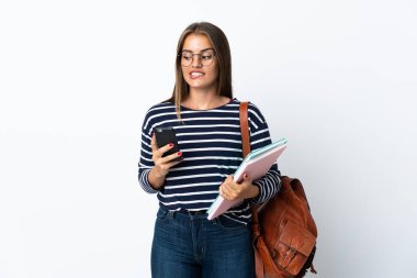 Beyaz arka planda izole edilmiş genç bir bayan. Elinde kahve ve bir şeyler düşünürken cep telefonu var.