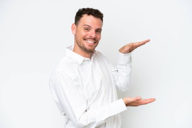 Beyaz arka planda izole edilmiş beyaz tenli yakışıklı bir adam ilan vermek için kopyalama alanı tutuyor.