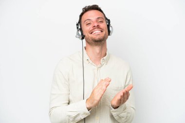 Beyaz arka planda izole edilmiş bir kulaklıkla çalışan beyaz pazarlamacı beyaz adam bir konferansta sunumdan sonra alkışlıyor.