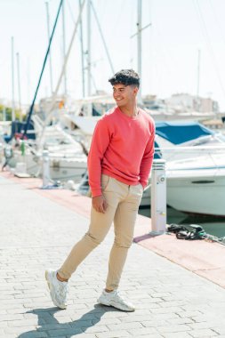 Genç İspanyol adam dışarıda mutlu bir ifadeyle.