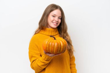 Beyaz arka planda izole edilmiş bir balkabağı tutan genç ve güzel bir kadın.