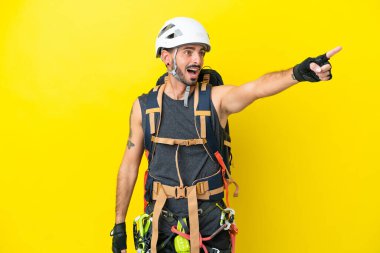 Sarı arka planda izole edilmiş Kafkasyalı genç dağcı