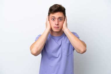 Beyaz arka planda izole edilmiş yakışıklı Brezilyalı adam hayal kırıklığına uğramış ve kulaklarını kapatmış.