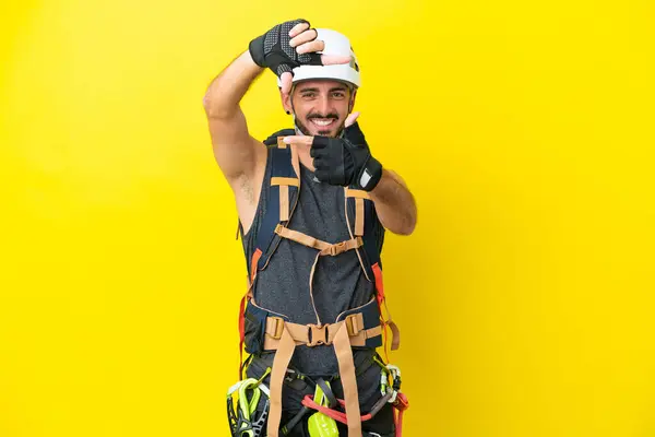 Young Caucasian Rock Climber Man Isolated Yellow Background Focusing Face — Stock Photo, Image