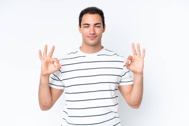 Beyaz arka planda Zen pozisyonunda beyaz tenli genç bir adam