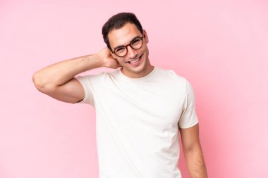 Pembe arka planda izole edilmiş genç beyaz adam gülüyor.