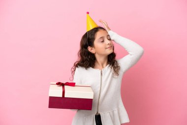 Pembe arka planda izole edilmiş bir hediye tutan küçük beyaz kız bir şey fark etti ve çözüme niyetlendi.