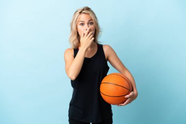 Basketbol oynayan genç Rus kadın mavi arka planda izole edilmiş, sağa bakarken şaşırmış ve şok olmuştu.