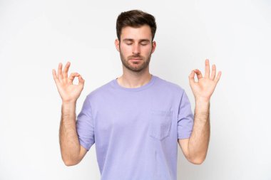 Beyaz arka planda Zen pozisyonunda beyaz tenli genç bir adam