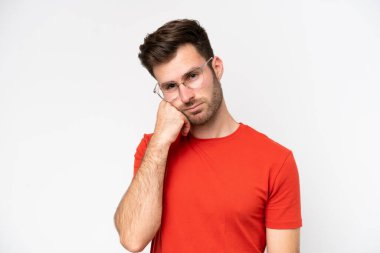 Beyaz arka planda gözlüklü ve üzgün yüzlü beyaz bir adam.