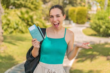 Dışarıda elinde pasaport tutan genç ve güzel bir kadın.