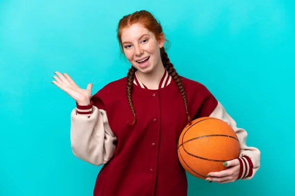 Młoda Rudowłosa Kobieta Gra Koszykówkę Odizolowana Niebieskim Tle Zaszokowanym Wyrazem — Zdjęcie stockowe