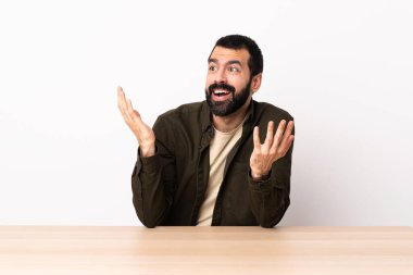 Masada sakallı, yüzünde sürpriz ifade olan beyaz bir adam..