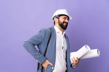 Miğferli genç bir mimar, elinde, gayret sarf ettiği için sırt ağrısından muzdarip, izole edilmiş, mor bir arka planın planları var.