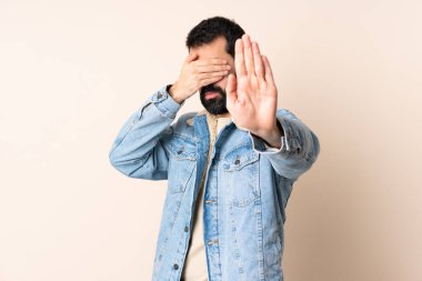 İzole edilmiş arka planda sakallı beyaz adam jesti durduruyor ve yüzünü kapatıyor.