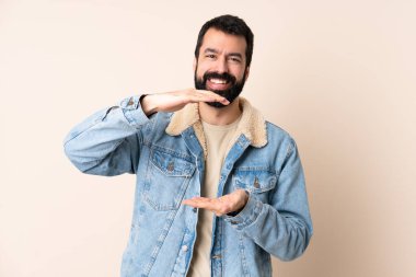 İzole edilmiş arka planda sakallı beyaz bir adam bir ilan vermek için avucunun içinde hayali bir fotokopi makinesi tutuyor.