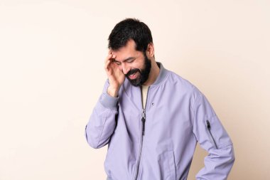 Sakallı, ceketli, soyutlanmış arka planda gülen beyaz bir adam.