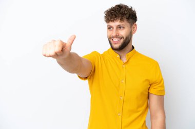 Beyaz arka planda izole edilmiş yakışıklı beyaz bir adam baş parmak hareketi yapıyor.