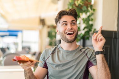 Sashimi 'yi açık havada tutan genç yakışıklı bir adam çözümü bulmak için parmağını kaldırıyor.