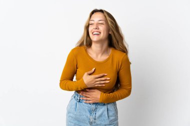 Mavi arka planda izole edilmiş genç sarışın kadın çok gülümsüyor.