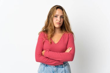 Mavi arka planda izole edilmiş genç sarışın kadın üzgün hissediyor