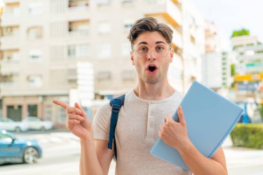 Dışarıdaki yakışıklı öğrenci şaşırmış ve işaret ediyor.