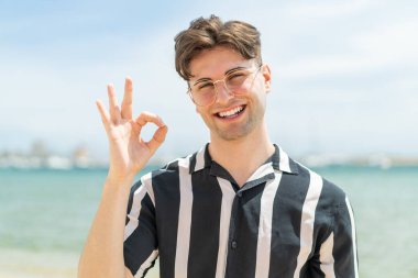 Gözlüklü, yakışıklı bir genç.