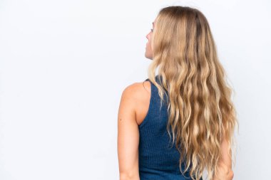 Genç Rus kadın beyaz arka planda izole edilmiş ve arkasına bakıyor.