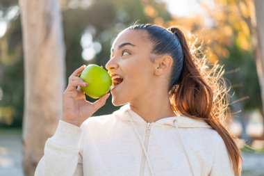 Elma tutan genç ve güzel bir bayan.