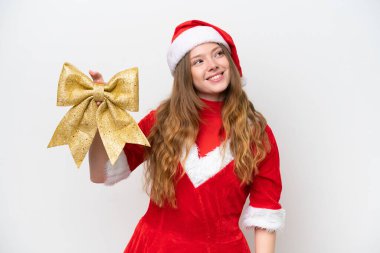 Beyaz arka planda izole edilmiş Noel yayı tutan beyaz elbiseli genç beyaz kadın gülümserken yukarı bakıyordu.
