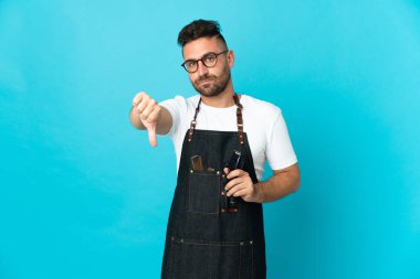 Önlüklü bir berber, olumsuz bir ifadeyle baş parmağını gösteriyor.