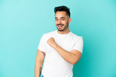 Mavi arka planda izole edilmiş beyaz bir adam zaferi kutluyor.