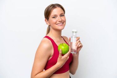 Beyaz arka planda, bir elma ve bir şişe suyla izole edilmiş genç, güzel sarışın kadın.