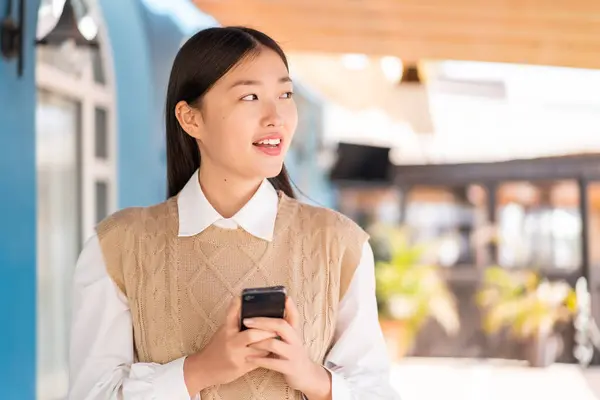 Joven Mujer China Aire Libre Utilizando Teléfono Móvil Mirando Hacia — Foto de Stock