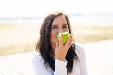 Bir elma tutan orta yaşlı kadın