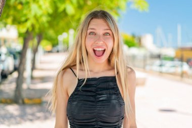 Yüzünde sürpriz bir ifade olan sarışın genç bir kadın.