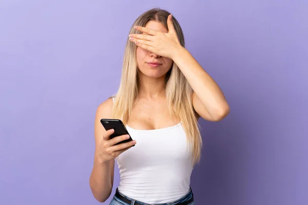 Young Blonde Woman Using Mobile Phone Isolated Purple Background Covering — Stock Photo, Image