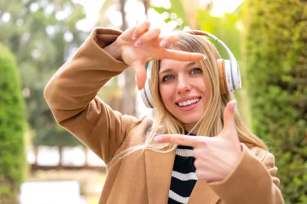 Молодая Симпатичная Блондинка Слушает Музыку Наушниках Открытом Воздухе Фокусируя Лицо — стоковое фото