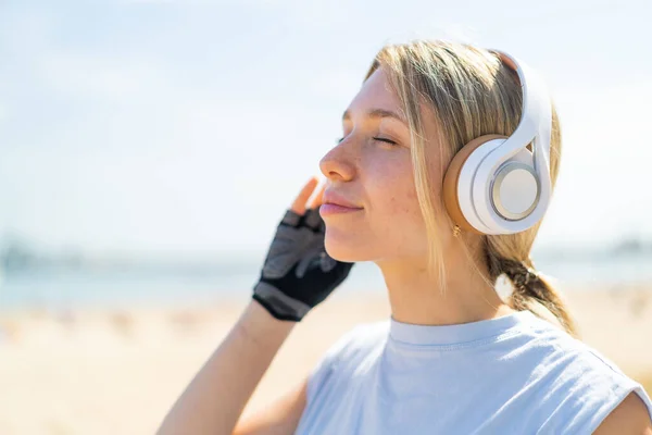 Молода Блондинка Відкритому Повітрі Носить Спортивний Одяг Слухає Музику Навушниками — стокове фото